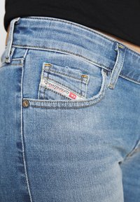 Ljusblå denimjeans med en figurnära passform. Har en bakficka med en logotagg och kontrasterande gula sömmar.