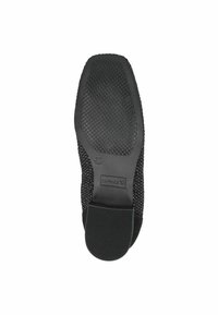 Suela de zapato negra con un agarre de goma texturizada y parte superior tejida. Presenta la marca y la etiqueta de tamaño 37 en la suela.