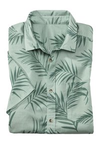 Svetlo zelena majica s kratkimi rokavi iz mehkega materiala, ki ima vzorec palmovih listov, eno žepno torbico na prsih in rjave gumbe.