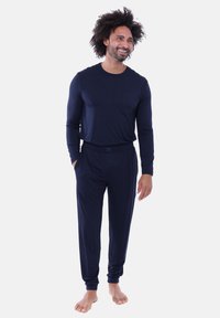 Marineblauw pyjamaset gemaakt van zachte stof, met een longsleeve top met een borstzak en bijpassende broek met elastische tailleband.