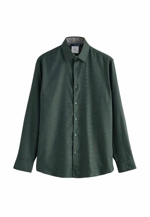 Tumši zaļš garo piedurkņu pogājams krekls ar smalku rakstu, klasisku apkakli un rakstainu iekšējo apkakles oderi, izklāts uz balta fona.