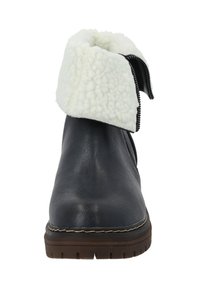 Botín negro de cuero hasta el tobillo con puño de pelo sintético blanco, superficie texturizada y suela de goma con un patrón de relieve prominente y costuras contrastantes.