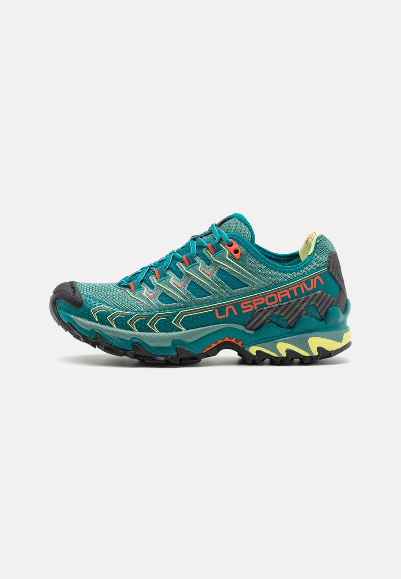 Teal athletic shoe with a breathable mesh upper, reinforced toe cap, multi-directional tread, and orange and yellow accents.