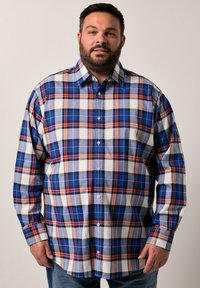 Camicia a maniche lunghe a quadri con motivi blu, bianchi e rossi. Realizzata in tessuto dalla superficie liscia, presenta un colletto con bottoni e bottoni frontali.