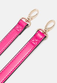 Różowy lakierowany pasek ze złotymi metalowymi detalami; charakteryzuje się gładką powierzchnią i kontrastującymi czarnymi krawędziami, zaprojektowany do torebek lub akcesoriów.