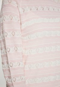 Helle rosa gestrickte Pullover mit horizontalen weißen und rosa Streifen. Besitzt aufwendige Spitzenmuster und strukturierte Bereiche.