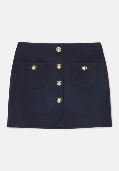 Navy blue skirt with a fitted design, featuring a row of five gold buttons and two front pockets with curved flaps. Soft fabric texture.