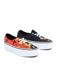 Vans sneakers med en livlig tie-dye-design i orange och gult på ena skon, och helt svart på den andra, med vita plattformssulor.
