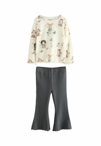 Hellbeige Langarmshirt mit floralem und Charakterdruck, kombiniert mit dunkelgrauen, gerippten Schlaghosen mit gewelltem Saum.