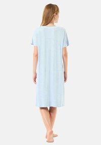 Camisón azul claro, a la altura de la rodilla, con mangas cortas y un escote redondeado, hecho de una suave tela texturizada. Diseño simple, sin patrones.