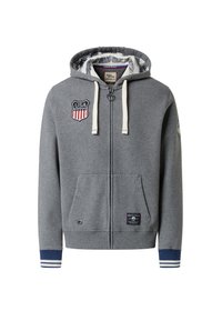 Felpa grigia con zip realizzata in tessuto morbido, caratterizzata da un badge USA, tasche frontali e polsini a righe blu. L'interno presenta un motivo unico.