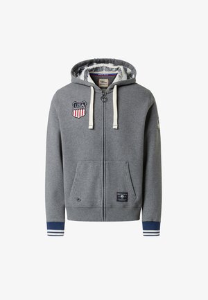 Grau zip-up Hoodie aus weichem Stoff, ausgestattet mit einem USA-Abzeichen, Fronttaschen und gestreiften blauen Bündchen. Das Innere hat ein einzigartiges Muster.