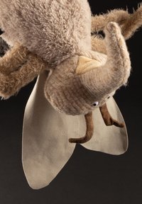 Stuffed insect toy with beige fuzzy body, elongated head, brown antennae, and tan fabric wings. Notable texture and fabric details.
