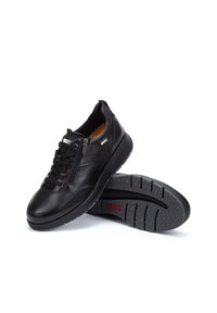 Zapatillas de cuero negro con un perfil bajo, que cuentan con un cierre de cordones en la parte delantera, cremallera lateral y suela de goma texturizada. Sin patrones ni acentos visibles.