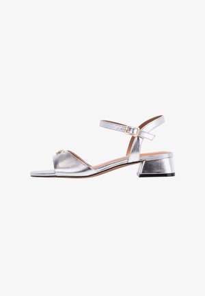Silver metallic high-heeled sandals with ankle strap, open toe, and a small, block heel. Features a decorative accent on the front.