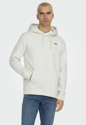 Felpa bianca con tasca frontale, cappuccio con coulisse e piccolo logo ricamato sul petto. Abbinata a jeans blu. Tessuto di trama morbida.