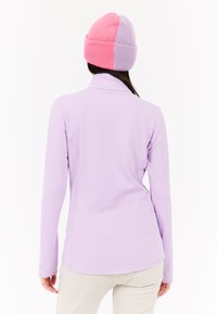 Priliehavý top s dlhým rukávom vo svetlofialovej látke, s falošným golierom a bezšvovým dizajnom. Obsahuje pletenú čiapku v ružovej a fialovej farbe.