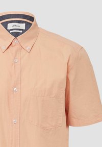 Korte mouwen overhemd van licht perzikkleurige stof met een button-down kraag, één borstzak en subtiele verticale geribbelde structuur.