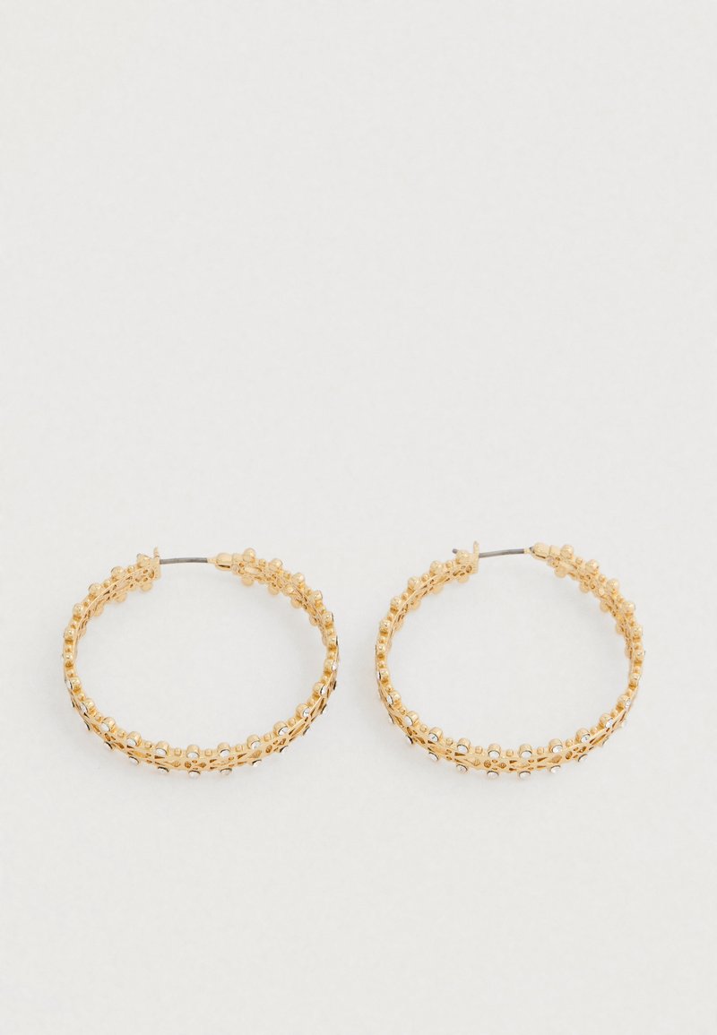 Zlaté kruhové náušnice s textúrovaným dizajnom a malými okrúhlymi korálkami pozdĺž vonkajšieho okraja. Ľahké a so zabezpečeným zapínaním.
