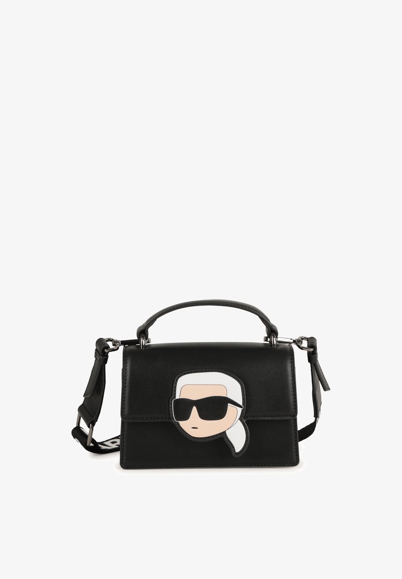 Black structured handbag in leather with a cartoon face design on the front, featuring sunglasses and a white ponytail accent.