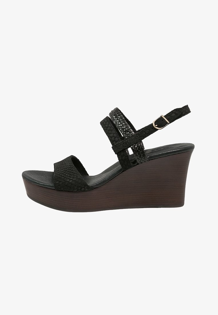 Sandale compensée noire avec brides texturées, fermeture à boucle et talon plateforme en bois.
