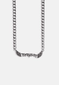 Sølvkæde med vedhæng i midten, der staver "ESTHERAY", flankeret af detaljerede vingedesigns på en hvid baggrund.