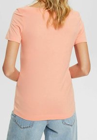 Kurze Ärmel, hellrosa T-Shirt aus weicher Baumwolle; Rundhalsausschnitt und figurbetonter Schnitt mit glatter Textur und sauberem Saum.