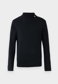 Crna pletiva turtleneck pulover s dugim rukavima, s rebrastim manžetama i okovratnikom, te malim metalnim logotipom na okovratniku.