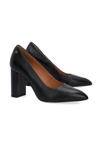 Černé kožené lodičky na vysokém podpatku s špičatou špičkou a čtveratým podpatkem. Hladký povrch s béžovým interiérem a jemnými ozdobnými prvky.