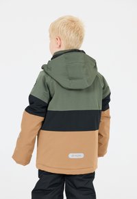 Grøn, sort og brun farveblokeret jakke med hætte, der har et logo på den nederste ryg og en holdbar tekstur.