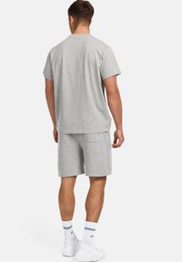 Grå bomulds t-shirt og shorts sæt, der har et enkelt design, regular fit og blød tekstur, med en baglomme på shortsene.