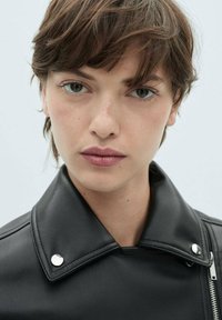 Black leather jacket with a wide collar, silver snap buttons, and a visible zipper. Smooth texture against a light background.