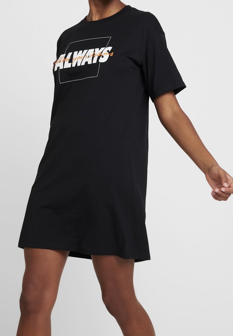 Robe T-shirt noire à manches courtes avec un texte graphique blanc et orange "ALWAYS" encadré par un rectangle. Confectionnée en coton doux.