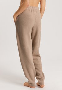 Beige, gestructureerde loungebroek met een elastische tailleband, zijzakken en een relaxte pasvorm. Geschikt voor casual of loungewear gebruik.