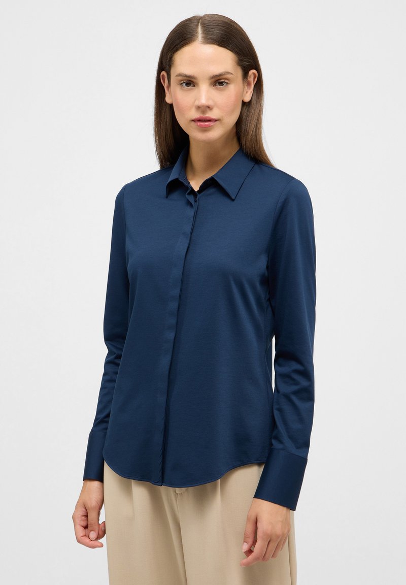 Camicetta a maniche lunghe blu navy con colletto e chiusura frontale con bottoni; realizzata in tessuto morbido; orlo arrotondato; polsini strutturati.