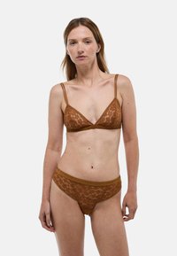 Brassière en dentelle marron et culotte assortie. Les deux présentent de délicats motifs en dentelle, des bretelles ajustables et une bordure élastique pour le confort et l'ajustement.