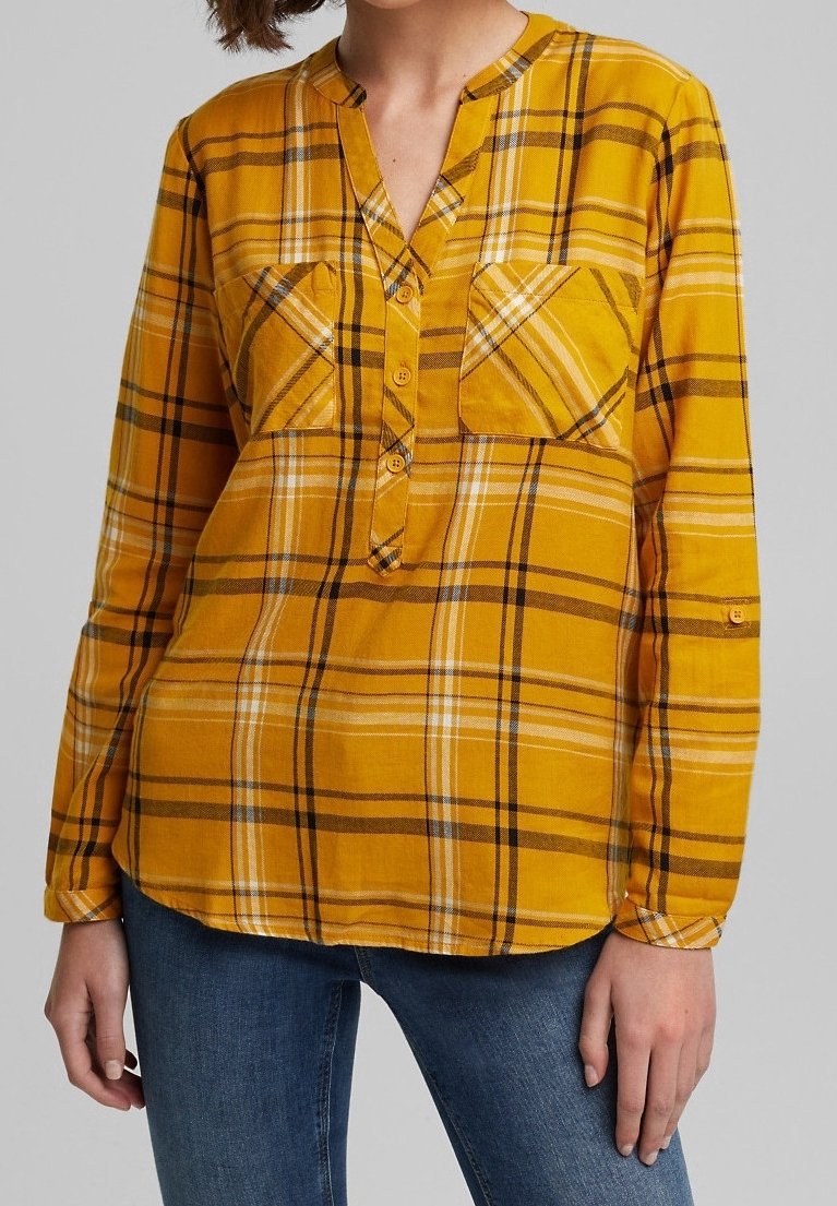 Chemise à manches longues à carreaux jaunes et noirs, dotée de deux poches poitrine, d'une fermeture à boutons sur le devant et d'une coupe décontractée, confectionnée dans un tissu doux et texturé.