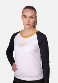 Langarm-T-Shirt mit einem weißen Körper und schwarzen Ärmeln, das auf der Vorderseite ein geometrisches Bärendesign in Gold und einen gelben Kragenrand zeigt.