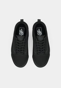 Sorte sneakers med en glatt overflate, rund tåform, snøring og synlige sømdetaljer. Vans-logo på tungen.