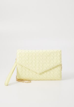 Żółty pleciony portfel kopertowy z klapką, odczepianym paskiem na nadgarstek i złotym akcentem łańcuszka. Gładka tekstura i prostokątny kształt.