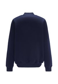 Granatowy sweatshirt wykonany z miękkiej tkaniny, z okrągłym dekoltem, długimi rękawami oraz ściągaczami przy mankietach i dolnej krawędzi dla dodatkowej struktury.