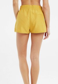 Geel, lichtgewicht shorts met een elastische tailleband, een enkele achterzak en een gladde textuur, met een ontspannen pasvorm.