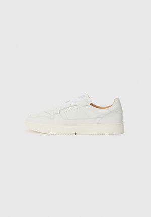 Witte leren sneaker met een textuur oppervlak, ronde neus en geperforeerde details. Voorzien van witte veters en een lichtbeige rubberen zool.