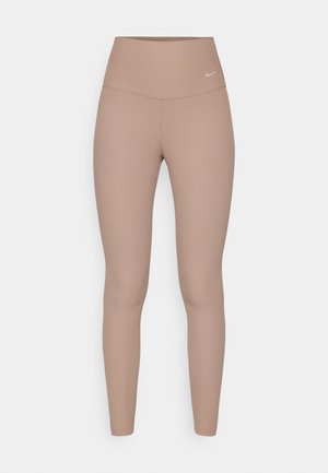 Leggings de cintura alta, com textura canelada, na cor castanha clara, com uma cinta suave e um discreto detalhe do logótipo na anca, apresentando um silhueta ajustada.