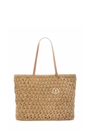 Tkany worek ze słomy z kwiatowym wzorem, jasnobrązowymi skórzanymi paskami na ramię i małym okrągłym złotym zawieszką wiszącą na jednym pasku.