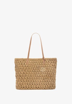 Tkany worek ze słomy z kwiatowym wzorem, jasnobrązowymi skórzanymi paskami na ramię i małym okrągłym złotym zawieszką wiszącą na jednym pasku.