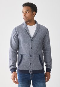 Blue knit cardigan with shawl collar, front buttons, and two pockets. Features ribbed cuffs and hem, made from soft, textured fabric.