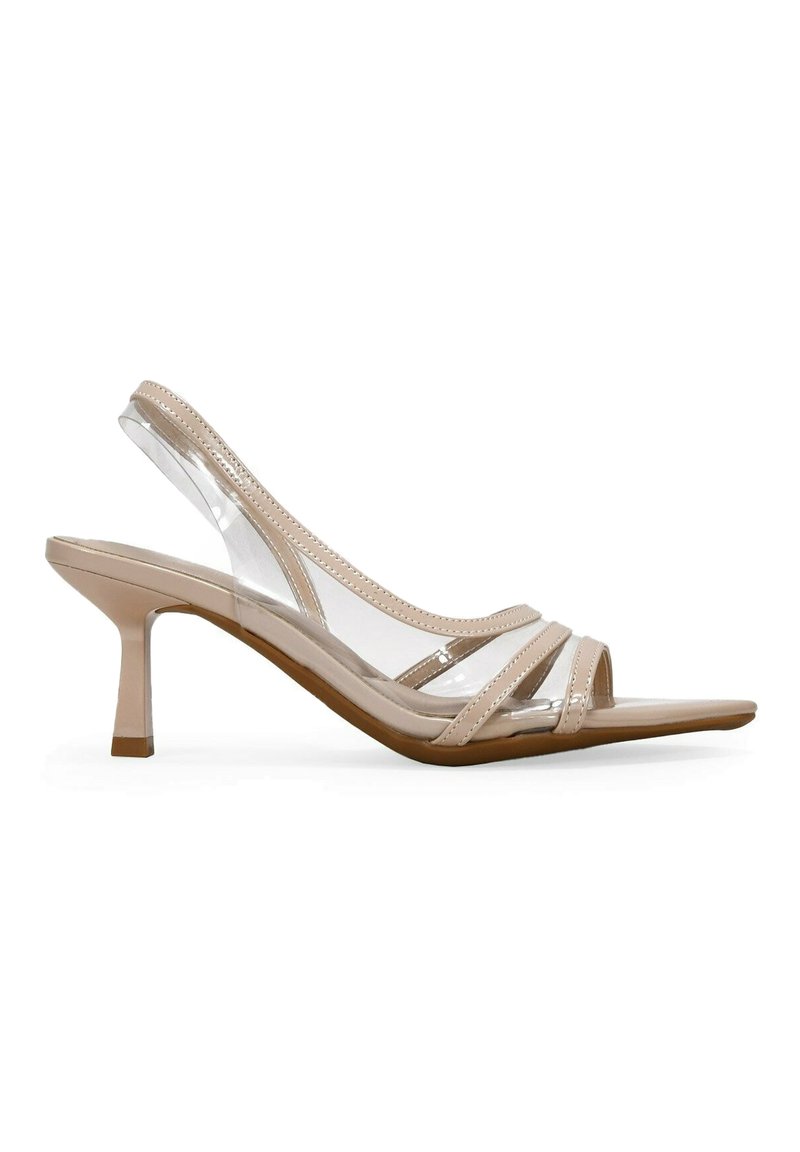 Tacones desnudos de tirante atrás con punta descubierta y tiras transparentes, que presentan un tacón delgado y un acabado suave y brillante. Plantilla ligeramente contorneada.