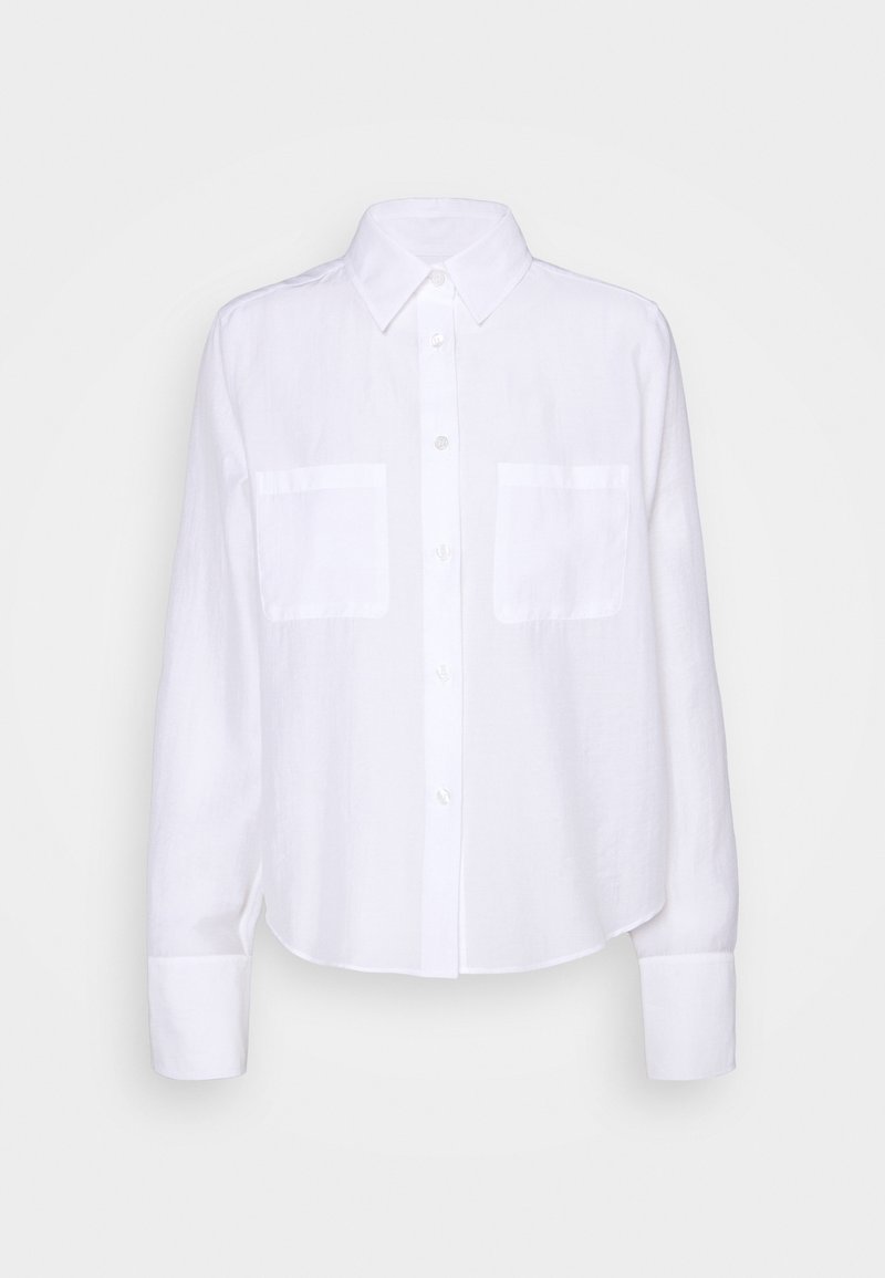 Chemise blanche à manches longues avec col, deux poches poitrine et poignets boutonnés sur fond uni.