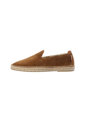 Zapatos de ante marrón sin cordones, con puntera afilada y suela de cuerda de yute. Diseño minimalista con un pequeño logotipo en el talón.